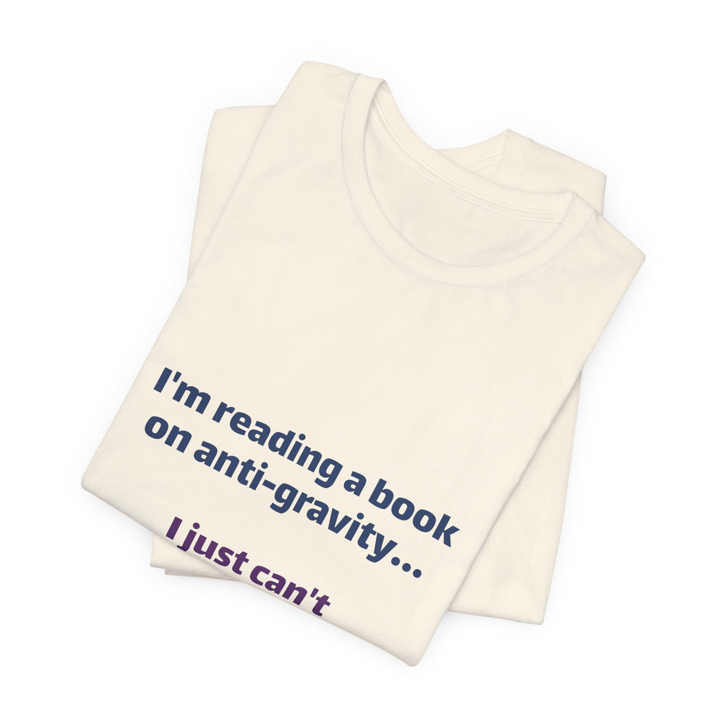 Funny Book Lover T‑Shirt — “I’m reading a book on anti-gravity… I just can’t put it down.”