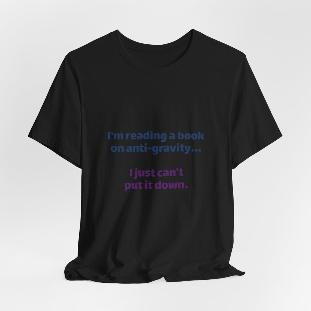 Funny Book Lover T‑Shirt — “I’m reading a book on anti-gravity… I just can’t put it down.”