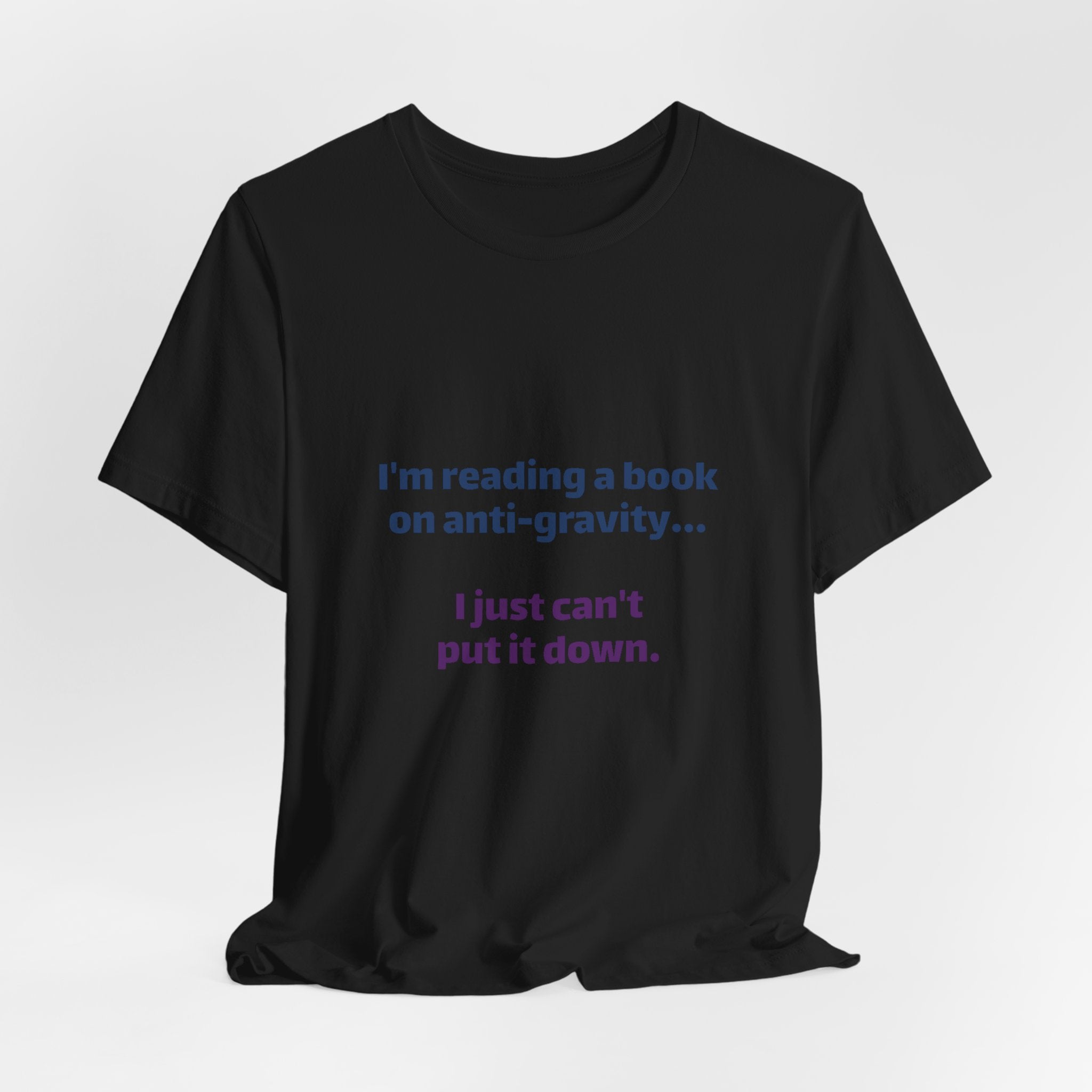 Funny Book Lover T‑Shirt — “I’m reading a book on anti-gravity… I just can’t put it down.”