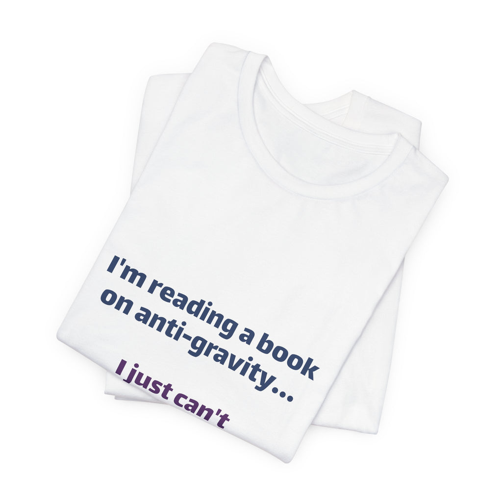 Funny Book Lover T‑Shirt — “I’m reading a book on anti-gravity… I just can’t put it down.”