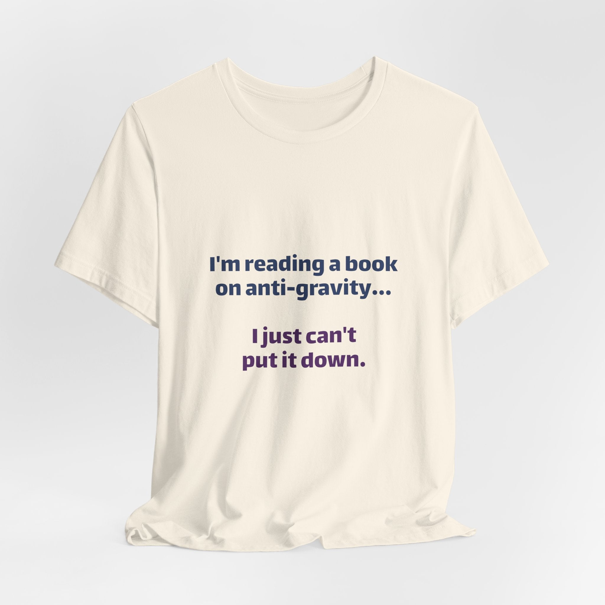 Funny Book Lover T‑Shirt — “I’m reading a book on anti-gravity… I just can’t put it down.”